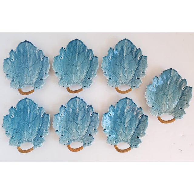 Unique set of Mid-Century blue majolica leaf form plates with woven cane handles. The plates feature a blue glaze molded...