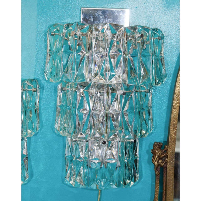 A pair of large Kinkeldey three tier sconces with clear faceted crystals and chrome mounts. Six lights per sconce. Twelve...