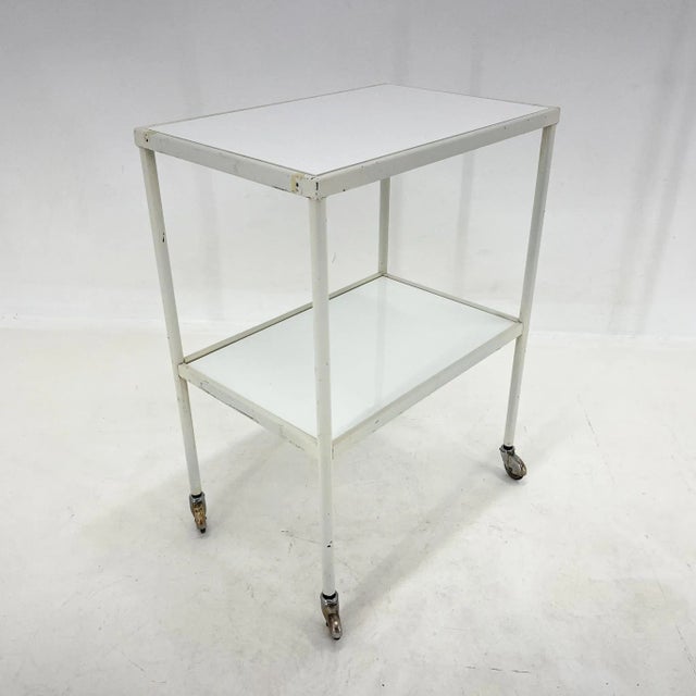 Vintage medical table or trolley with original patina. The bottom shelf is original, made of opaxite glass. The top...