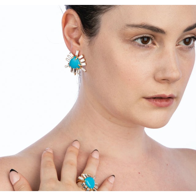 The Abigail Studs, fashioned from semi-precious stones, showcase a distinctive triangle center encircled by baguettes,...