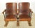 Vintage theater seats made of a dark stained wood seat and backrest with cast iron frames. The unit is screwed to three...