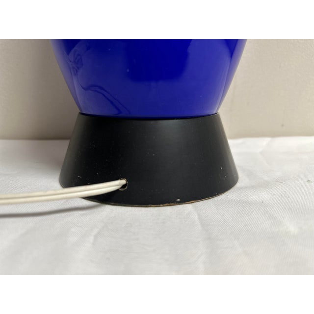 An Mid-Century two tone turquoise and royal blue glass lamp on a black ceramic or metal base. This vintage lamp is in such...