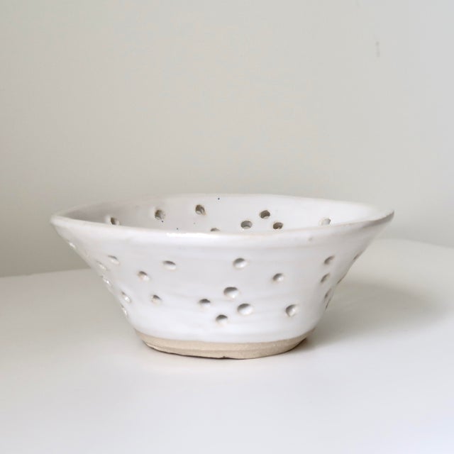 Handmade studio pottery berry bowl or ceramic colander featuring a softly irregular organic form and hand-pierced drainage...