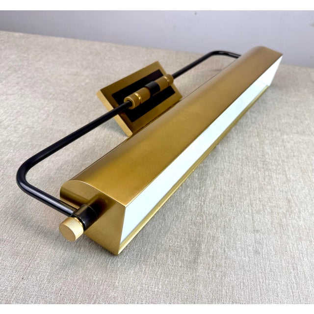 A gorgeous overhead wall mounted “Bowery” picture light in brass with black accents by Hudson Valley Lighting. The light...