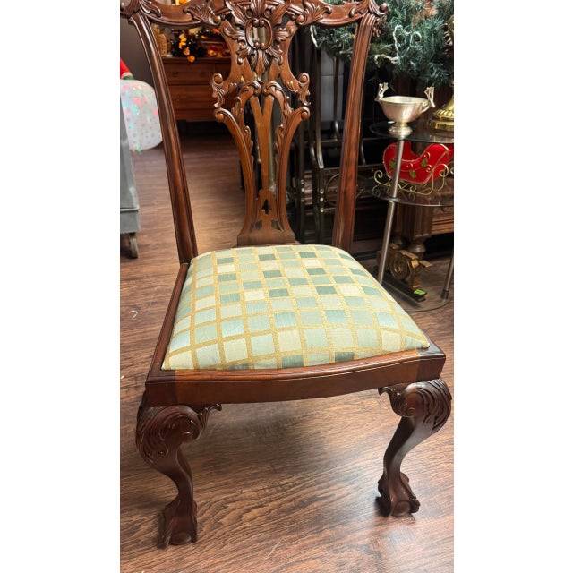 A handsome set of six Chippendale-style side chairs with richly carved, pierced splat backs and shaped crest rails. The...