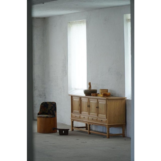A charming low-profile sideboard crafted in oak and designed in the style of Henning Kjærnulf, Denmark, 1960s. The piece...