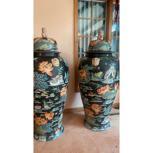 Pair of monumental palace jars , porcelain, lids have Foo Dogs and bases have Foo Dog handles, Famille Noire pattern, each...