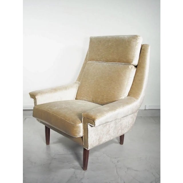 Danish 1950s lounge chair reupholstered in lightly shiny beige velvet. Round stained wood legs. Very comfortable seat.