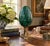 A beautifully proportioned malachite egg in richly veined shades of green and black resting on a neoclassical style brass...