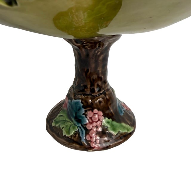 A beautifully modeled majolica footed bowl featuring a raised leaf motif and a sculptural trunk‑form pedestal accented...