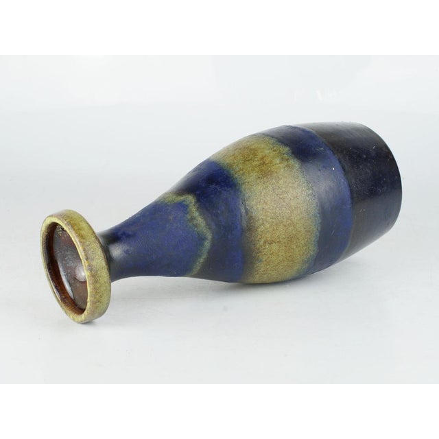 Ceramic vase from the 1950s. Made by Ruscha Keramik in West Germany. Base mark: 865-24. Dark blue base color combined with...