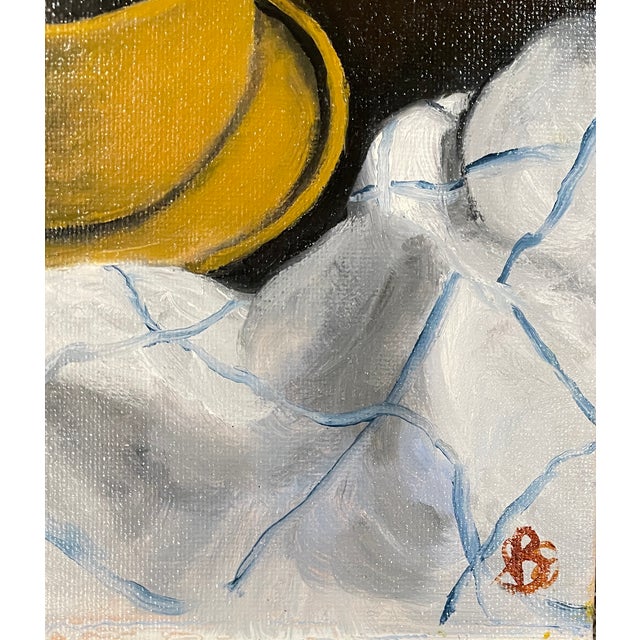 1990s oil on canvas board of a yellow tea or coffee cup and saucer. Signed with initials lower right. The painting has...