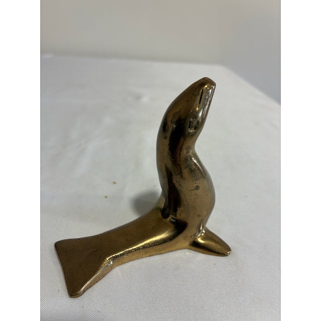 A charming brass sea lion with a graceful upturned head and outstretched flippers. Its clean, streamlined form and golden...