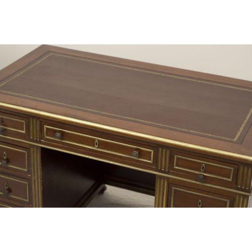 A nice 19th century French mahogany desk with brass banding to edges of writing surface and on drawer faces, additionally...