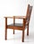 This antique Arts and Crafts armchair features a strong architectural form with wide flat arms, a stylized cutout splat...