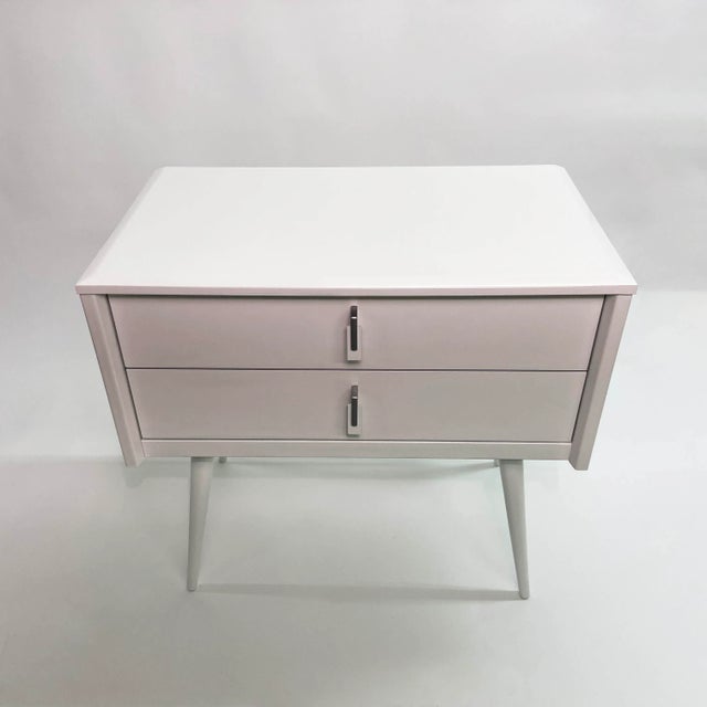 Offering a sleek and stylish French Mid-Century Modern double drawer nightstand or end table. It has been newly refinished...