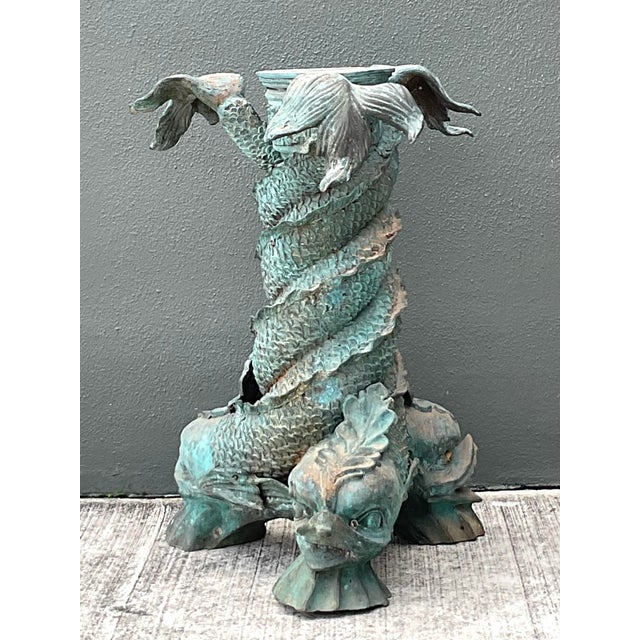 This striking vintage table pedestal features a masterfully cast trio of mythical koi fish, or dolphins, spiraling upward...