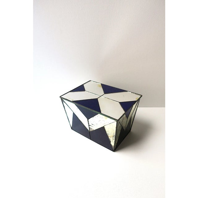 A beautiful royal blue glass and mirrored tole metal box, Art Deco period, Europe, circa early-20th century. Box has a...