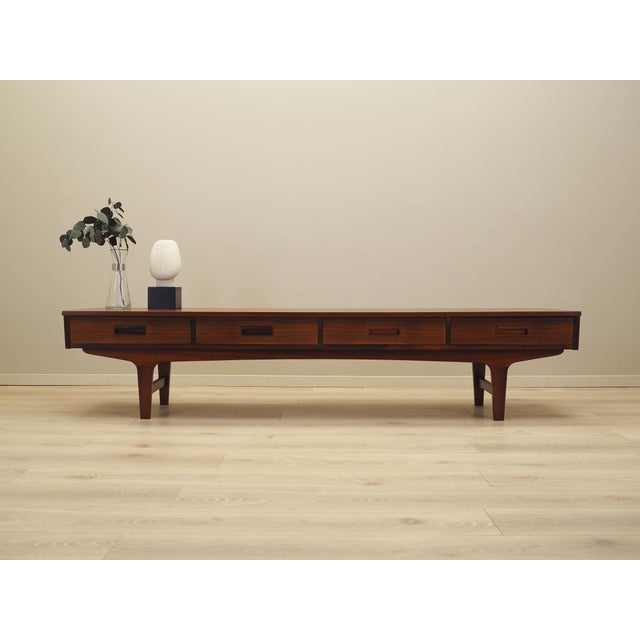 The lowboard was made in the 1970s in Denmark. The structure is covered with walnut veneer. The legs and handles are made...