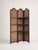 Three-panel folding screen in a dark-stained wood frame, likely oak, with inset woven cane panels throughout. Simple rail-...