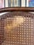 An elegant bentwood settee featuring three distinct cane-backed panels and scrolled armrests. Has a small tear on the left...
