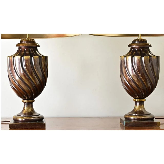 Exceptional pair of vintage brass table lamps, these footed urn bases have surprising weight behind their twisting design....