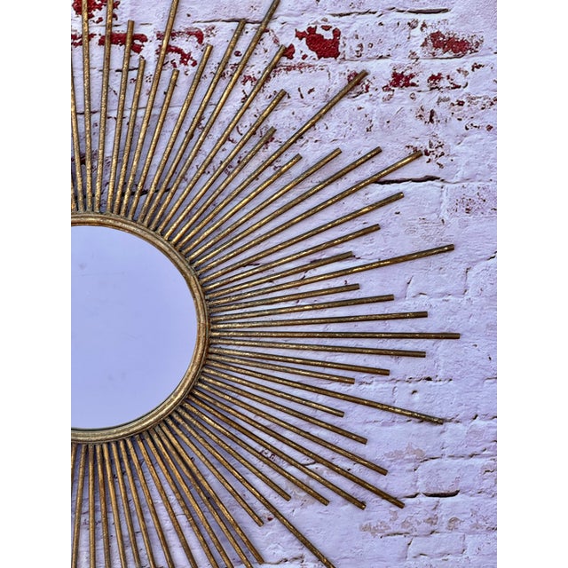 Large, Stunning iconic Mid-Century Sunburst Mirror with bursts of elongating rays surrounding a round convex mirror. The...