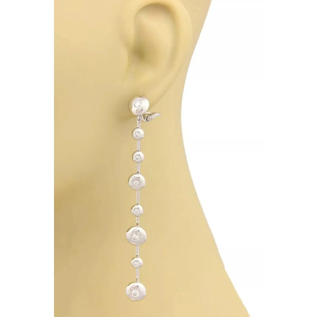 This is a designer Koesia 18k white gold and diamond long drop earrings. The pair is beautifully crafted in 18k white gold...