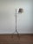 This vintage wrought iron floor lamp dates to the 1940s and features an adjustable swing arm with sculptural scroll...