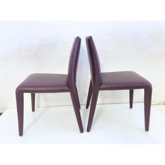 Two B&B Italia Vol au Vent side chairs. Designed by Mario Bellini, 2001. Bordeaux leather. Good used condition. Light...