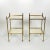 A pair of French Art Deco cocktail tables featuring fluted brass frames and square antique mirror shelves. Each table...