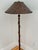 Arts & Crafts style wrought iron floor lamp on tripod legs with original shade. The lamp, shade, and finial all share the...
