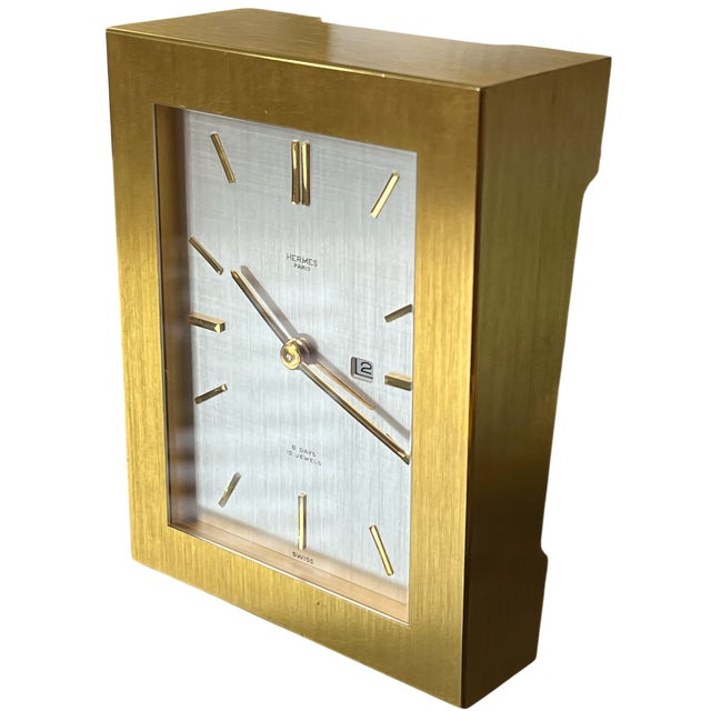 A refined and exceptionally well-crafted vintage brass desk clock by Hermès Paris, dating to the 1960s–1970s, featuring a...