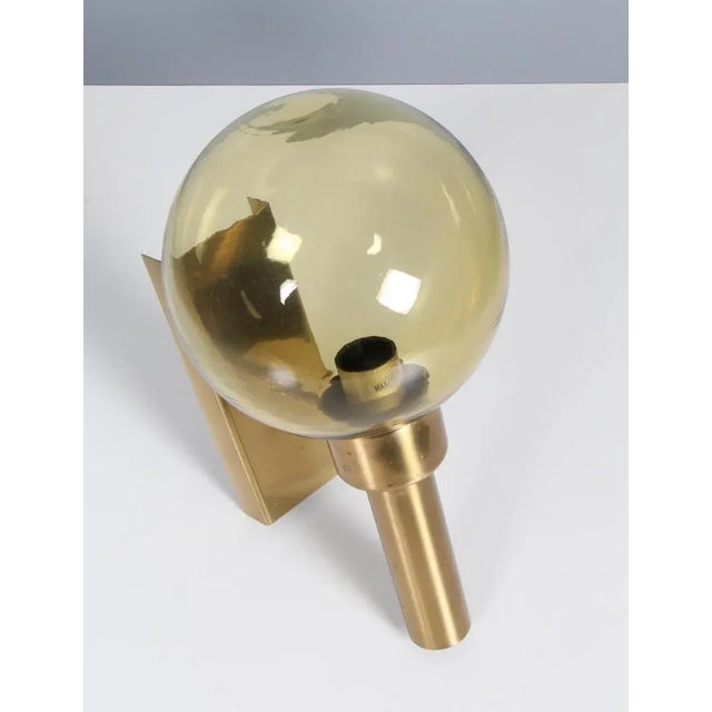Vitrika wall lamp in glass and brass. Made by Vitrika. This piece is attributed to the mentioned designer/maker. It has no...