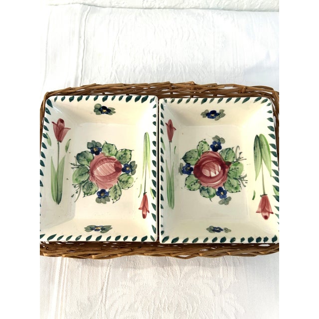 Lovely pair of mid-century porcelain bowls hand-painted in a colorful floral design with accompanying wicker basket....