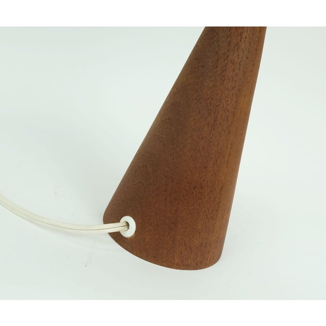 A very beautiful Danish table lamp from the 1960s. The conical base is made of teak, and the lampshade is made of woven...