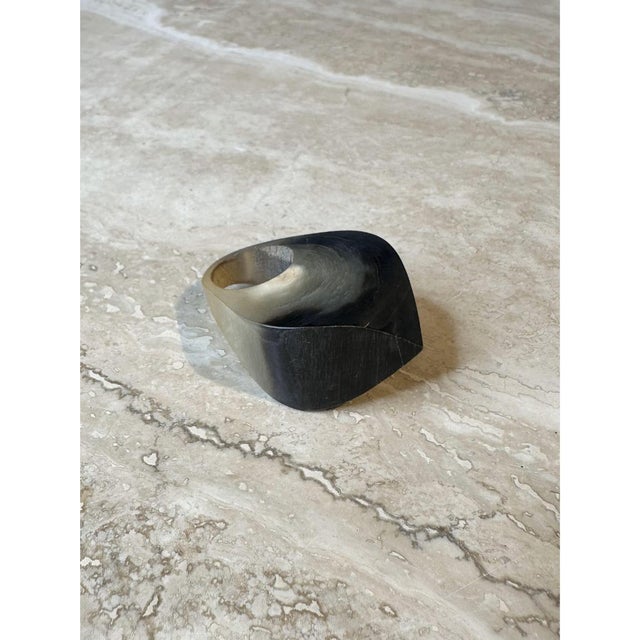 This vintage ring is a bold, sculptural band carved from natural horn, shaped as a wide, softly tapered dome with a...