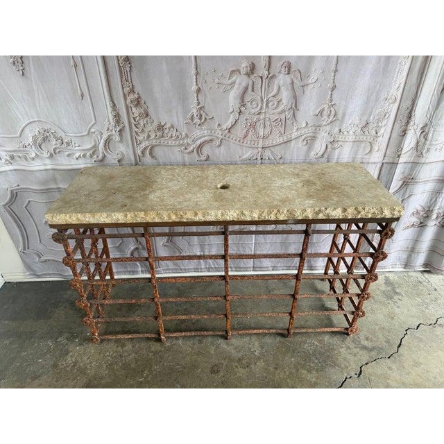 An exceptional rustic stone console table featuring a substantial textured stone top paired with an architectural hand-...
