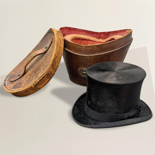 This late 19th-century English leather top hat box, paired with an American-made beaver fur top hat, exudes timeless...