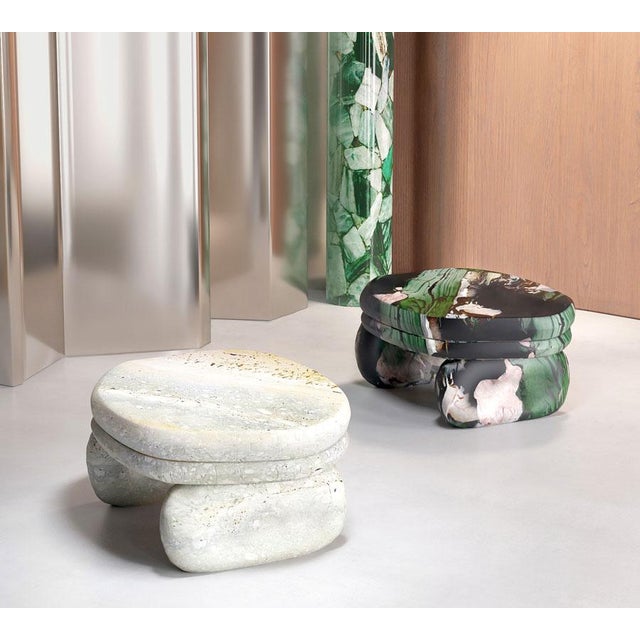 Minimalist coffee table with a slight asymmetry, in natural stone or solid wood.