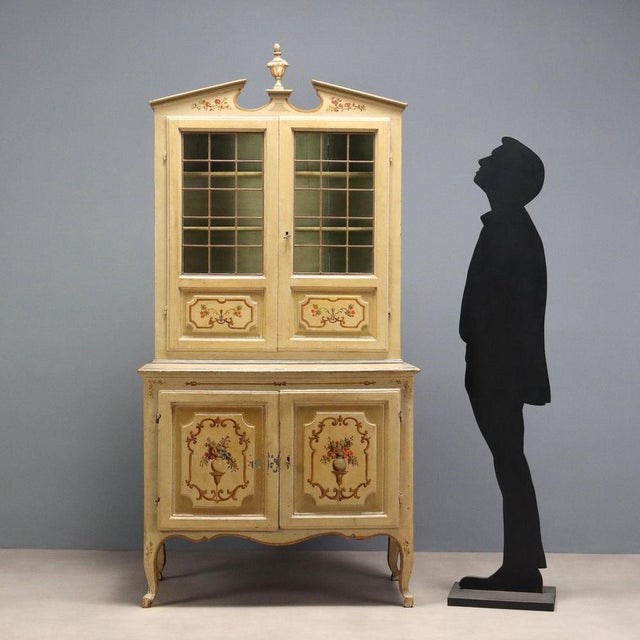 Baroque double-body sideboard in lacquered and painted wood. The upper part features an architectural cornice with a...