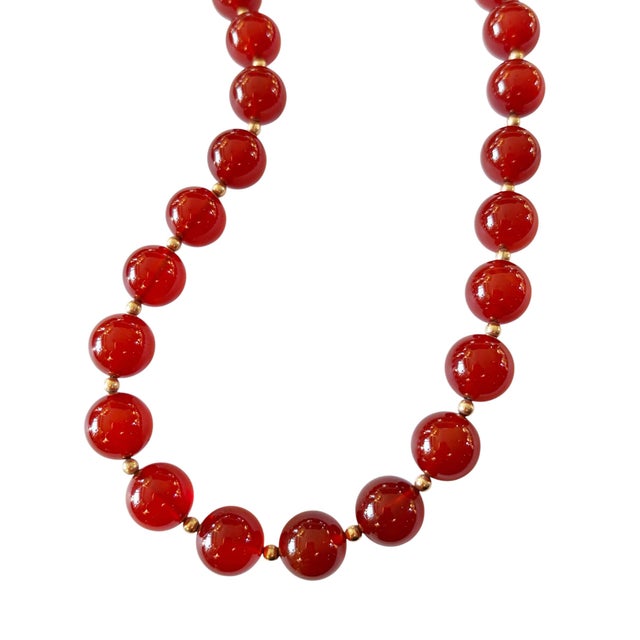 An exquisite vintage piece, this necklace showcases a striking carnelian gemstone interspersed with gold-tone spacer beads...