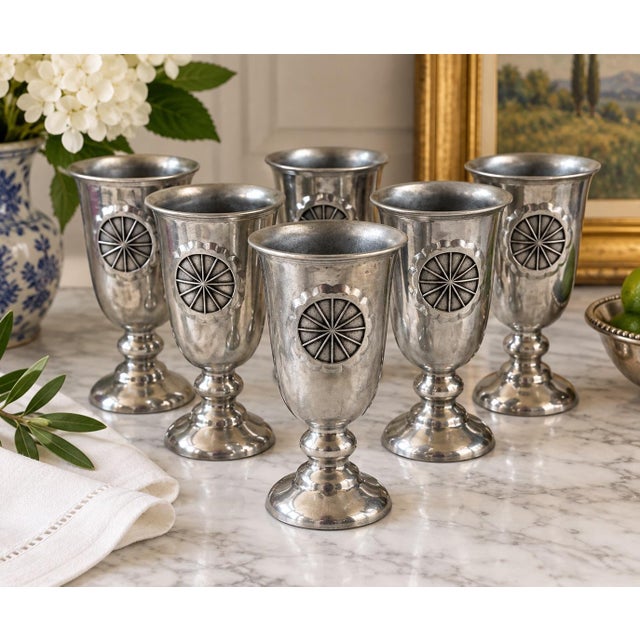 A handsome set of six vintage American cast-metal water goblets featuring bold dimensional sunburst medallions. Each...