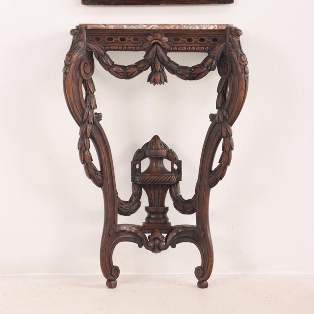 A 19th century French carved walnut narrow marble top wall mount console table with conforming trumeau mirror with Cherubs...