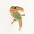 Vintage brooch in the shape of a bird, specifically a toucan, with resin components in ivory, coral, and turquoise blue...