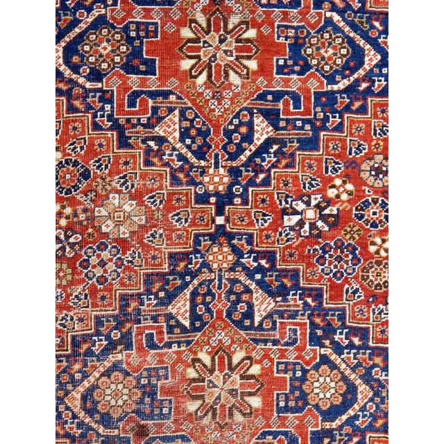 This antique Qashgaie rug, made of high-quality wool, features a rich rust and navy color palette. The medallion geometric...