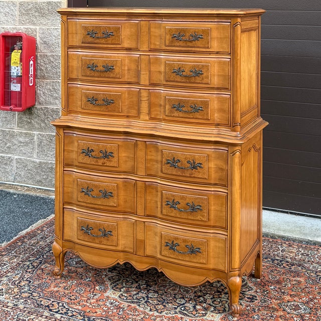 A vintage Thomasville French Louis XV chest on chest highboy dresser in golden brown maple & burl wood with six massive...