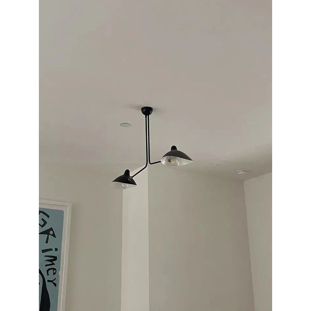 The iconic design of the Three Arm Multi-Light Pendant by Serge Mouille lends a striking presence in a modern home....