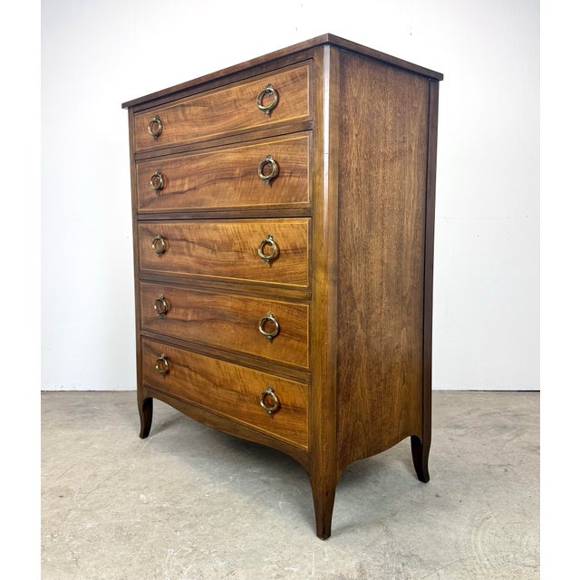 A gorgeous and high-quality Federal/Georgian-style walnut bow front chest of drawers by Baker Furniture with inlaid...