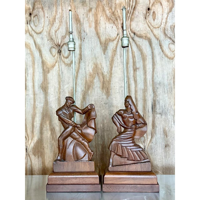 An exceptional pair of vintage hand-carved figural table lamps by the highly collectible Heifetz studio, each beautifully...